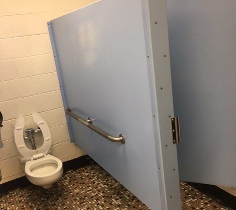The stall in the closed boys restroom is left without a door and repainted after extreme graffiti.  