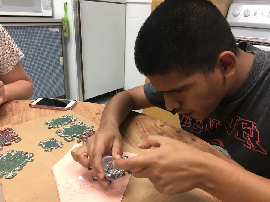 Cory Varela puts together puzzle pieces for the Christmas Tree project.