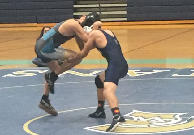 Eddie Ramirez, right, grapples with a Westminster wrestler on Wednesday night at Greeley West High School.