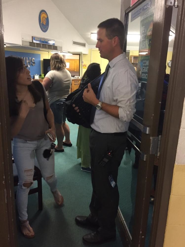 Principal+Mr.+Jeff+Cranson+discusses+the+first+day+of+school+with+junior+Luisa+Dominguez+outside+the+door+of+the+main+office.++