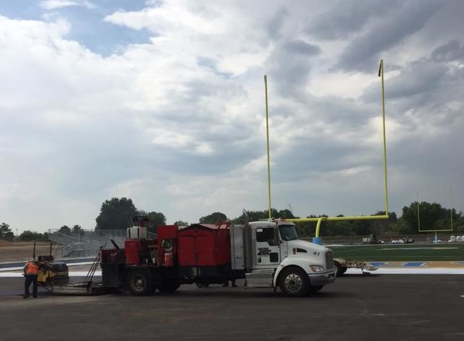 A maintenance truck is parked next to the new football field and track. The project will be finished on September 18.