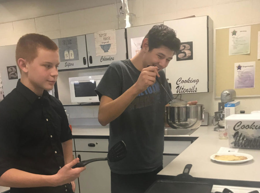 Freshmen Dillon Fenton and Joshua Hernandez Manriquez make crepes with French Club.