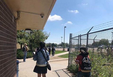 A student walks outside of the 500 hallway on her way to class Friday afternoon in front of a
security camera. Students will be on camera all day, each day as a new security
measure.  