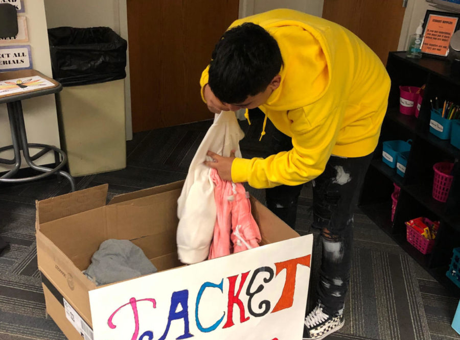 Freshman Derek Jimenez counts jackets in a box last week.  Jimenez is leading a coat drive through Friday of this week.