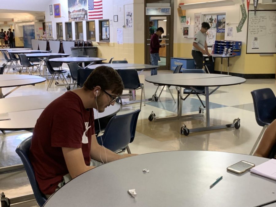 Junior Trent Parham sits in the commons listening to music during sixth period on Thursday during his off block. Many students use music to help get through the day.