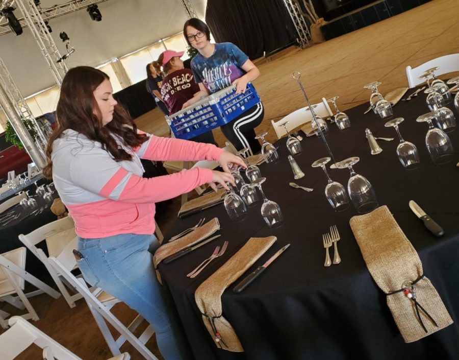 Senior Key Club members Destiny Hirzel and Katie Junker decorate tables for Cattle Barons Ball Fundraiser for the American Cancer Society.