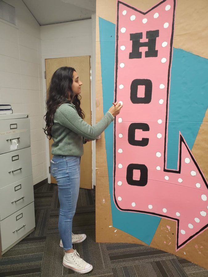 STUCO Grace Chahal preps a Homecoming banner in preparation for Saturday's dance.  