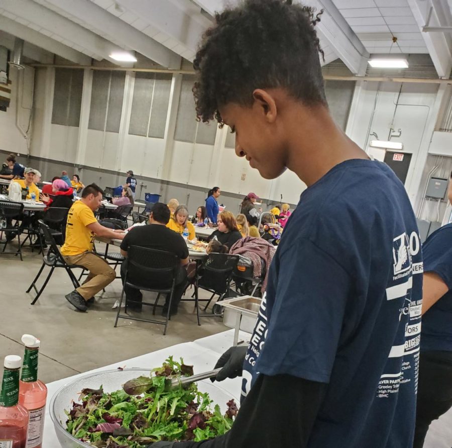 Senior Simon Tesfaselassie serves salad at Weld Project Connect.  The community service activity supported hundreds of less-fortunate community members.   