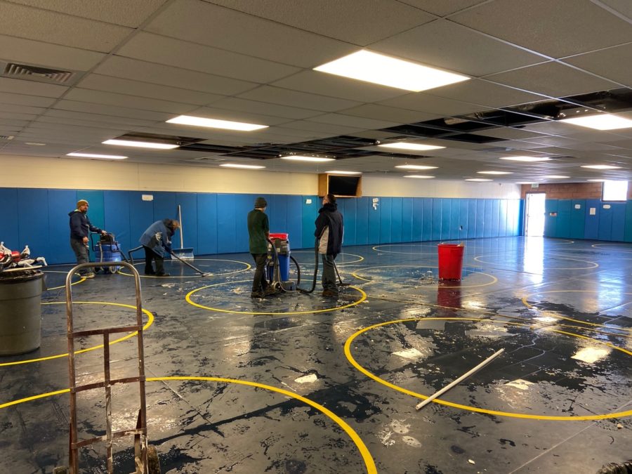 Greeley West staff members rush to mop up  water that flooded the wrestling room after a pipe burst on Wednesday afternoon.