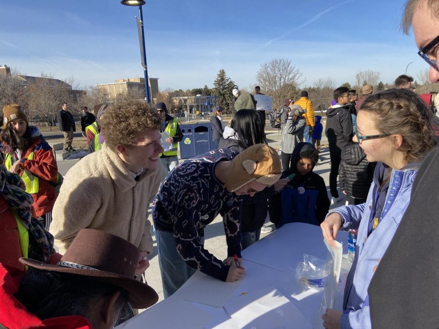 Jacob Evans and Brendan McCune make signs before the Martin Luther King march on Monday at the University of Northern Colorado. 