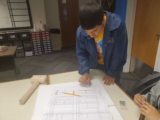 Sophomore Enrique Lugo analyzes a blueprint in his construction trades class. Construction trades is making adjustments to its curriculum as it is housed in a classroom this year. 