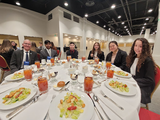 Mr. Rich Dufault, left, enjoys a meal at the Broadmoor with his DECA state participants.