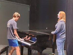 Senior Jeb Mathews and junior Maddie Zeller rehearse at the piano on the Greeley West stage for Matilda.  