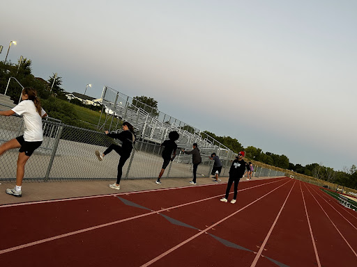 The Greeley West cross country team stretches on Friday morning at their 6 a.m. practice.  
