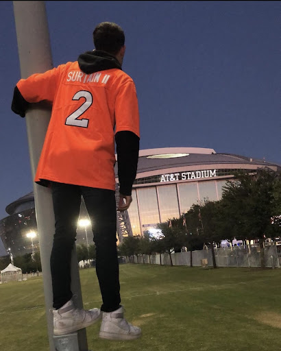 Senior Zaren Maldonado sports his orange  in front of the Dallas Cowboys stadium.