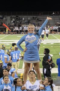 Senior cheerleader Tori Wells is elevated by her teammates.  Wells recently was offered a cheerleading scholarship at Bethel University in Kansas.