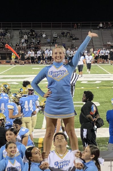 Senior cheerleader Tori Wells is elevated by her teammates.  Wells recently was offered a cheerleading scholarship at Bethel University in Kansas.