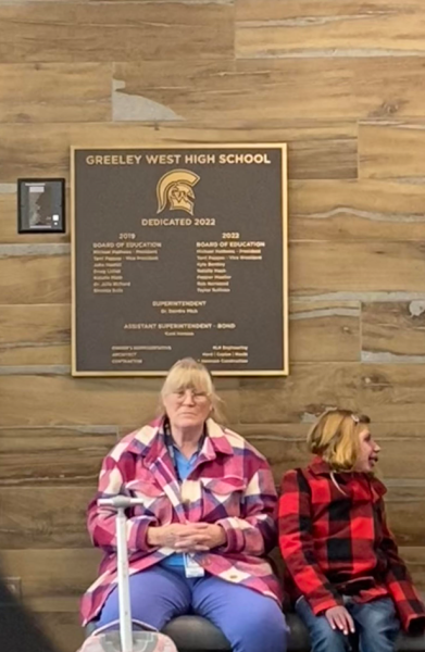 Greeley West special education assistant Ms. Julie Valdez and junior Nevaeh White wait for a bus at the end of the day last week in front of a plaque for the new Greeley West.  Ms. Rhonda Solis, a Spartan graduate, has her name on that plaque because she has helped fund the building of Greeley West and many of the programs (like unified sports) at District 6.  