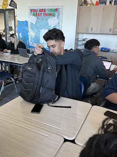 Daniel Sandoval sorts through his backback to prepare for his busy day, which includes school, work, and sports. 