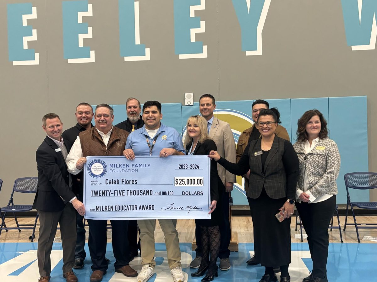 English teacher Mr. Caleb Flores poses for a picture with all of the dignitaries from the Milken Foundation moments after being rewarded $25,000 for being a great teacher.  