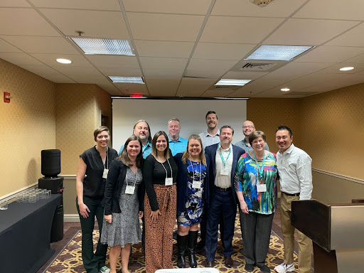 Greeley West teachers Tony Scott and Ryan Knoblock pose for a picture with conference attendants after presenting at an international conference for science education in New Orleans.