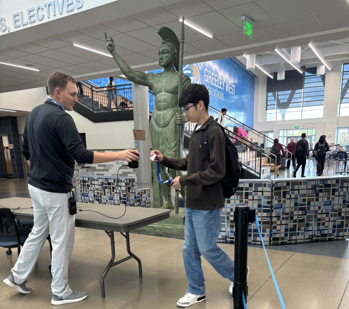 Greeley West assistant principal Mr. Kyle Appelhans scans IDs as students leave campus during B Lunch on Wednesday.  