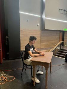 Senior Jeremy Piacenza thinks about his IB classes during a break last week during rehearsals.  Theater students always have some catching up to do after performances.  