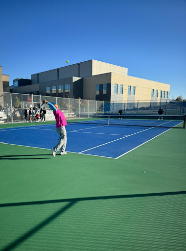 Mr. Cruz Rodriguez serves the ball during the teacher/student tennis tournament last week.