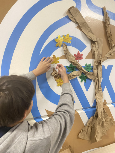 Freshman Angelo Morales hangs his grateful leaves on the Thanksgiving tree last Thursday as part of the FFA chapter meeting.