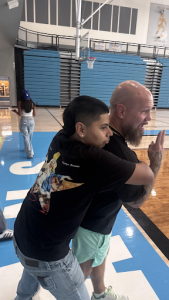 Greeley West senior Julian Melendez hugs PE teacher Mr. Aaron Bensinger during class last week.