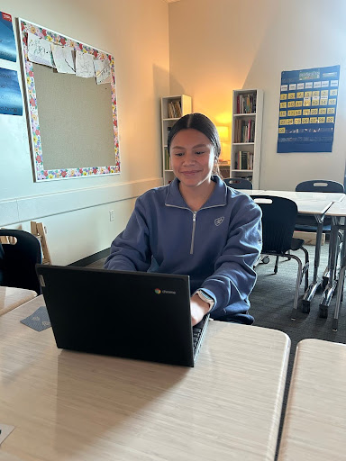 Aileen Mendiola poses for a picture trying to look busy in her IB Spanish class on Friday afternoon.